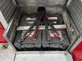 Two large batteries are connected with thick cables and terminal clamps in a metal compartment