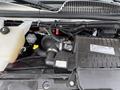 Close-up of the engine compartment of a 2017 Chevrolet Express showcasing various components including the air intake hose and fluid reservoirs
