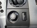 Close-up of a control panel in a 2016 Ford F-750 featuring a knob for lights and a button for the parking brake