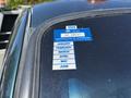 A 2008 Ford F-550 truck with a blue certificate of approval sticker on the windshield displaying expiration details for several months