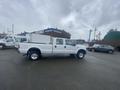 A white 2005 Ford F-350 SD pickup truck with a utility bed and dual rear wheels is parked on the lot with visible branding on the side