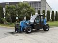 A blue 2020 Genie GTH-5519 telehandler with black forks attached located in a green outdoor area