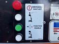 Control panel of a 2000 JLG 12SP featuring an emergency shut-off button and function enable switch with various colored buttons