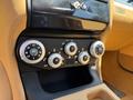 Interior controls of a 2005 Ferrari 612 Scaglietti featuring round dials for climate control and air settings