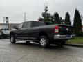 A 2020 RAM 3500 truck in a dark gray color with a crew cab design and chrome accents parked at an angle with visible wheels and dual exhaust pipes