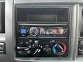 A close-up of an Alpine car stereo display with Bluetooth connectivity controls and various knobs for audio and climate settings