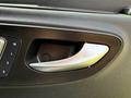 Close-up of a silver door handle inside a 2019 Mercedes-Benz Sprinter with a black textured panel and control buttons nearby