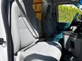 Interior of a 2021 Ford Econoline showing the driver's and passenger's seats with gray upholstery and seat belts