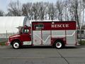 A red 1994 Freightliner FL80 fire rescue truck with silver accents and the word RESCUE prominently displayed on its side