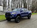 A blue 2022 Toyota Tacoma with a sleek design and black accents parked on a paved surface