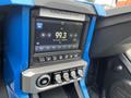 Dashboard of a 2020 Polaris Slingshot featuring a digital display with radio settings and climate controls in blue and silver design