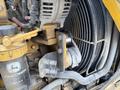 Close-up of a John Deere 310SJ 4x4 wheel loader engine showing the cooling fan assembly and component connections