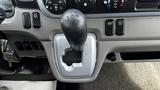 The gear shift of a 2018 Mitsubishi Fuso FE with a silver housing and black shift knob labeled with P R N M and symbols for drive modes