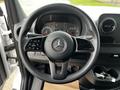 Steering wheel of a 2021 Mercedes-Benz Sprinter featuring controls for audio and cruise settings with a Mercedes logo in the center