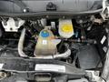 A view of the engine compartment of a 2016 RAM Promaster showcasing the coolant reservoir with a blue cap and yellow lid along with cooling hoses and other engine components