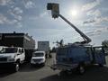 A blue 2010 Ford Econoline van with an elevated bucket lift extended from its roof
