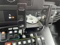 A mounted bracket with a metal plate and a knob is attached to a dashboard panel with various buttons and controls for a 2016 Chevrolet Express