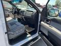 Interior of a 2014 Ford F-150 showing front seats dashboard and steering wheel with a focus on the driver's side door and control panel