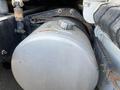 Close-up of a silver fuel tank on a 2022 Freightliner Cascadia truck with visible labels and connecting straps