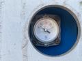 A pressure gauge with a round dial displaying measurements from empty to full and marked with quarter increments