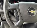 Close-up of the steering wheel of a 2019 Chevrolet Express showing control buttons for cruise control and the Chevrolet logo
