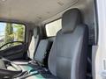Interior of a 2013 Isuzu NPR featuring two gray cloth front seats and a steering wheel with a simple dashboard layout