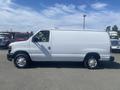 A white 2009 Ford Econoline van with a sliding side door and no windows on the sides