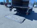 A 2015 Ford F-450 Super Duty truck with a lowered loading ramp at the back