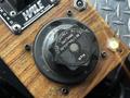 Close-up of a round control knob labeled with options for "OFF" and "ON" and instructions to "STOP ENGINES BEFORE SWITCHING" on a wooden panel