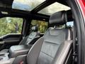 Interior view of a 2019 Ford F-150 showing black leather seats with Raptor branding and a panoramic sunroof