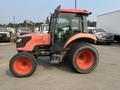 A 2010 Kubota M6040 tractor with orange wheels and a red cab, featuring a large front grille and sturdy tires designed for agricultural tasks