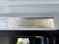 A metal plate displaying a compliance notice for a 2015 Mitsubishi Fuso FE truck detailing safety standards and regulations