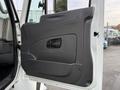 A close-up view of the interior door panel of a 2013 International Durastar 4300 featuring a smooth gray surface with a handle and a small window cutout