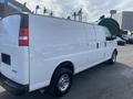 2022 GMC Savana cargo van with a white exterior and chrome wheels viewed from the rear side