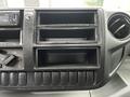 Dashboard of a 2014 Hino 195 featuring empty compartments and control knobs for audio and climate settings