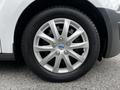 Close-up of a silver alloy wheel featuring ten spokes and a Ford logo at the center mounted on a black tire
