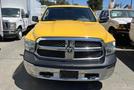 A 2015 RAM 1500 pickup truck with a bright yellow exterior and prominent chrome grille is parked in the foreground