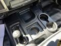 Interior console of a 2015 RAM 5500 featuring a gear shifter two cup holders and a storage compartment