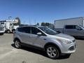 A silver 2014 Ford Escape parked with a slightly angled view showcasing its design and wheels