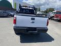 A 2016 Ford F-350 Super Duty truck with a white exterior and black bed, view from the rear showing the tailgate and bumper