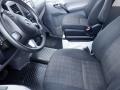 Interior view of a 2016 Mercedes-Benz Sprinter showing two front seats with a checkered pattern and a steering wheel with control buttons