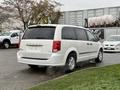 A white 2011 Dodge Grand Caravan with a rear view showcasing the taillights and chrome accents
