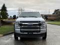 A white 2022 Ford F-550 truck facing forward with a chrome grille large headlights and side mirrors