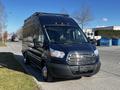 A 2017 Ford Transit van in dark blue with a silver grille and prominent front headlights parked on the street