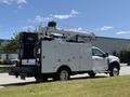 2023 Ford F-550 with an elevated crane and a utility service body featuring multiple closed storage compartments