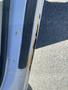 A side view of a 2013 Ford Expedition showing rust damage along the driver's door edge