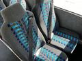 Two grey bus seats with a blue and turquoise striped pattern and safety seatbelts