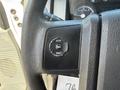 A close-up of the steering wheel of a 2012 Ford F-450 SD featuring a control button with options for setup info and reset.