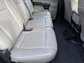 The interior of a 2020 Ford F-550 featuring rear leather seats with a center console and floor mats designed for utility and comfort