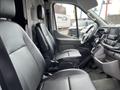 A 2023 Ford Transit interior featuring two front seats and a dashboard with controls and a display screen